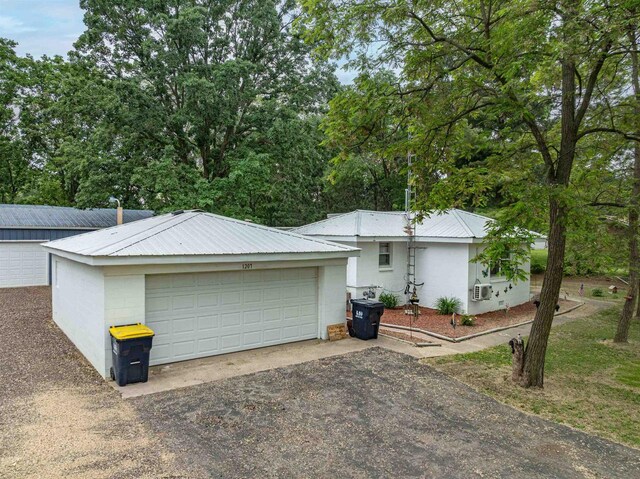 1207 S Main St, Necedah, WI 54646 - view of front of property with a metal roof, a detached garage, an outbuilding, and stucco siding