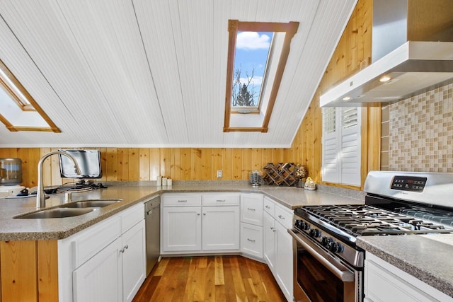 W5374 Westshore Dr, Elkhorn, WI 53121 - kitchen featuring stainless steel appliances, a skylight, wall chimney range hood, light wood finished floors, and white cabinets