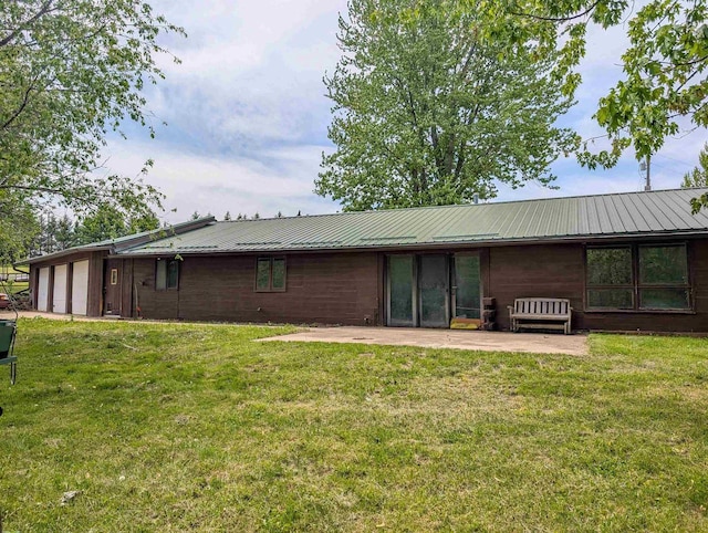 774 Enloe Rd, Rewey, WI 53580 - back of property featuring a yard, a garage, a metal roof, and a patio area
