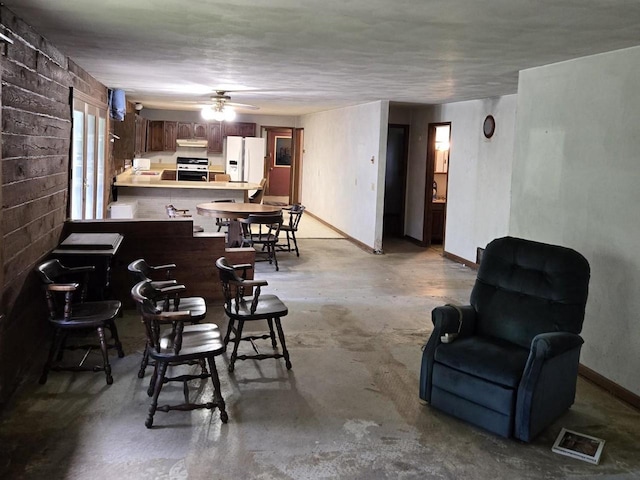 774 Enloe Rd, Rewey, WI 53580 - bar featuring white refrigerator with ice dispenser, range, concrete floors, under cabinet range hood, and ceiling fan
