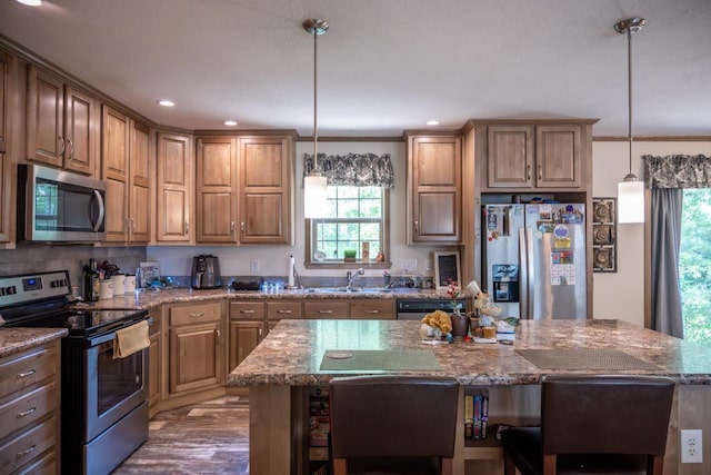 W5671 8th St, Necedah, WI 54646 - kitchen featuring appliances with stainless steel finishes, plenty of natural light, stone countertops, a kitchen breakfast bar, and recessed lighting