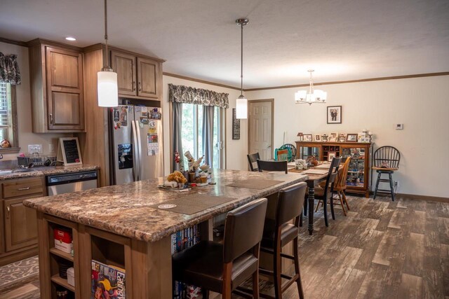 W5671 8th St, Necedah, WI 54646 - kitchen featuring stainless steel appliances, a chandelier, a breakfast bar area, dark wood finished floors, and a kitchen island