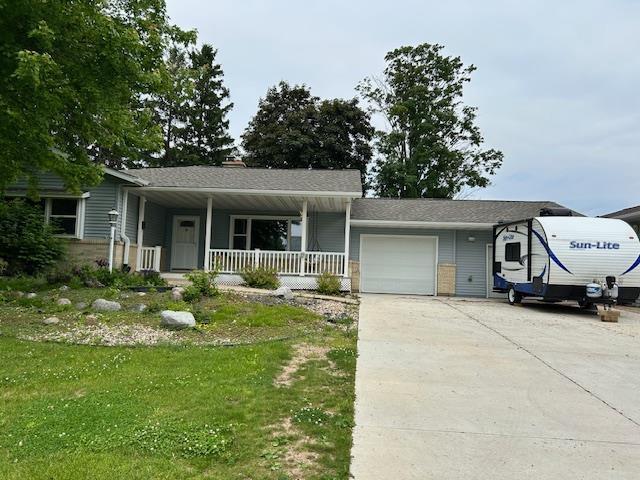 6592 Whalen Rd, Verona, WI 53593 - view of front facade with covered porch, an attached garage, concrete driveway, and a front yard
