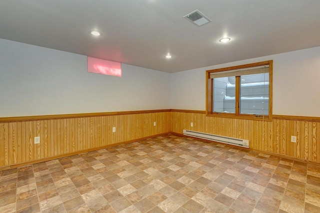 6592 Whalen Rd, Verona, WI 53593 - empty room with a baseboard heating unit, stone finish flooring, wainscoting, recessed lighting, and wooden walls