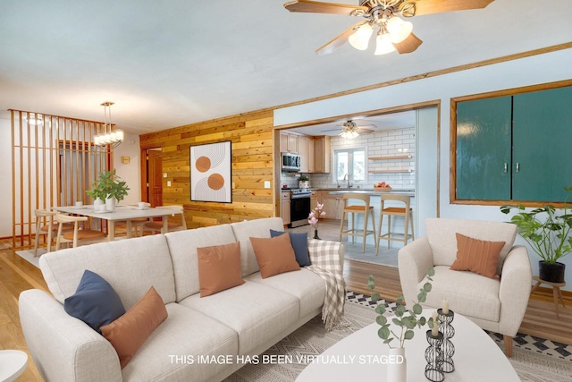 6592 Whalen Rd, Verona, WI 53593 - living room with light wood-style floors, a chandelier, a ceiling fan, and wooden walls