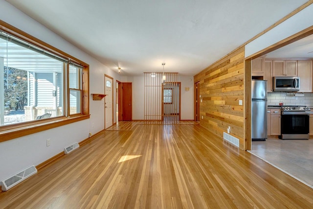 6592 Whalen Rd, Verona, WI 53593 - unfurnished living room featuring a chandelier, light wood-type flooring, and wood walls