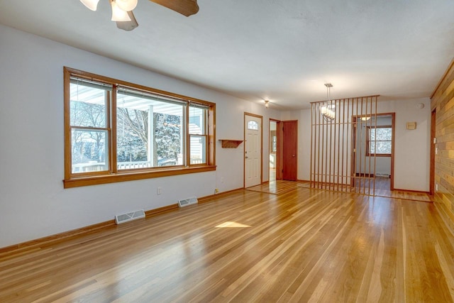 6592 Whalen Rd, Verona, WI 53593 - unfurnished room with light wood-style flooring, a ceiling fan, and a chandelier