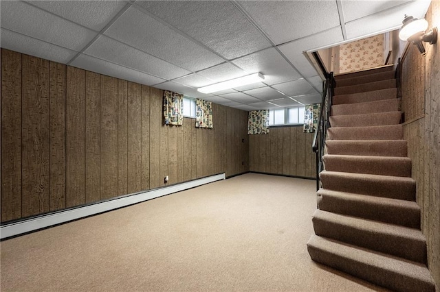 225 W Elm St, Chippewa Falls, WI 54729 - basement featuring a baseboard radiator, stairs, wood walls, light colored carpet, and a paneled ceiling