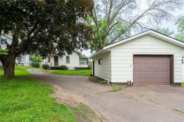 225 W Elm St, Chippewa Falls, WI 54729 - view of front of house featuring asphalt driveway, a front yard, and a detached garage