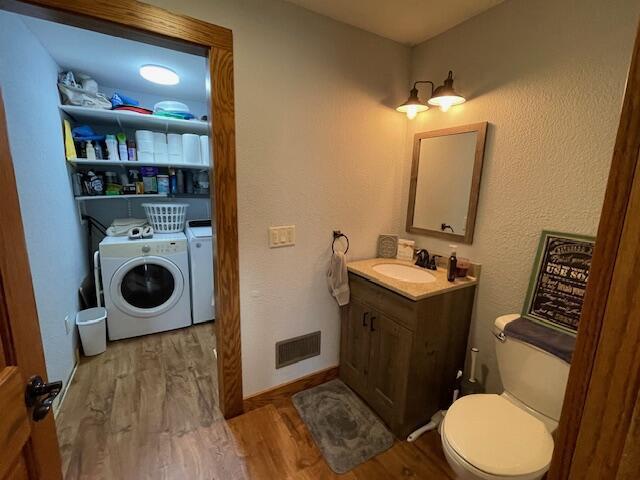 23826 18th St, Union Grove, WI 53182 - bathroom featuring washer and clothes dryer, wood finished floors, and vanity
