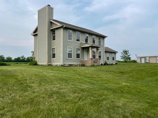 23826 18th St, Union Grove, WI 53182 - rear view of property with a chimney and a lawn