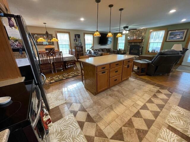 23826 18th St, Union Grove, WI 53182 - kitchen with open floor plan, plenty of natural light, a stone fireplace, stainless steel range with electric stovetop, and recessed lighting