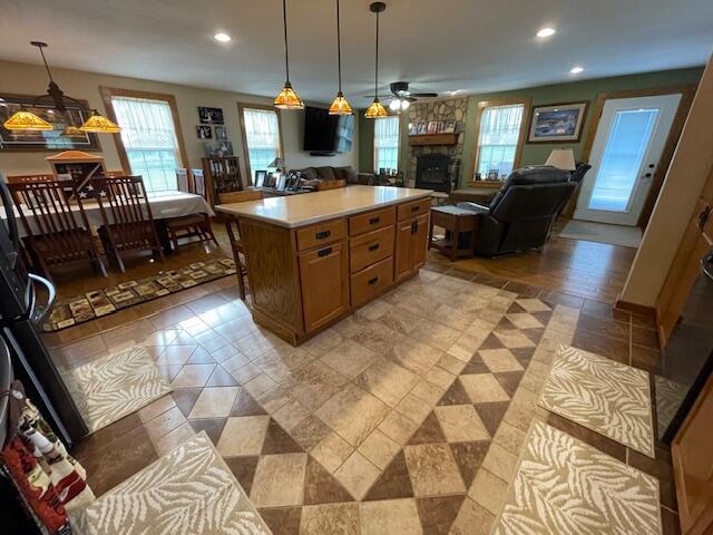 23826 18th St, Union Grove, WI 53182 - kitchen featuring a stone fireplace, light countertops, open floor plan, a ceiling fan, and recessed lighting