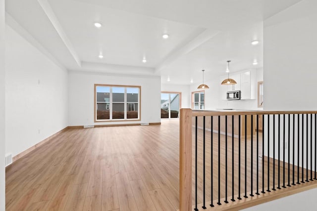 399 Battery Ave, De Pere, WI 54115 - unfurnished living room featuring a raised ceiling, light wood-style flooring, and recessed lighting
