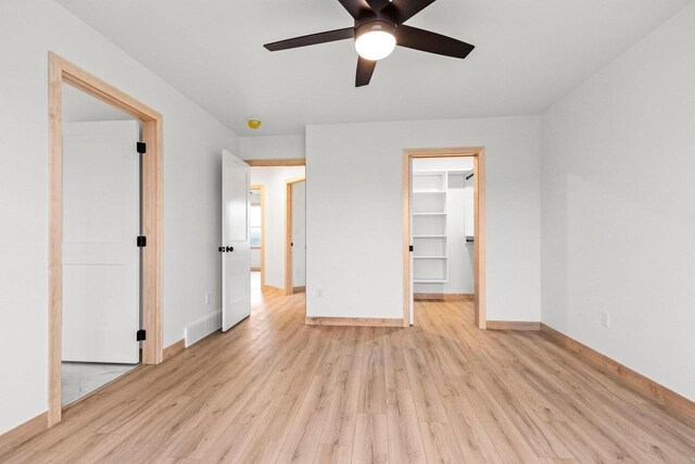 399 Battery Ave, De Pere, WI 54115 - unfurnished bedroom with light wood-style floors, a walk in closet, a ceiling fan, and a closet