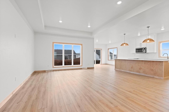 399 Battery Ave, De Pere, WI 54115 - unfurnished living room featuring recessed lighting, light wood-style flooring, and a tray ceiling