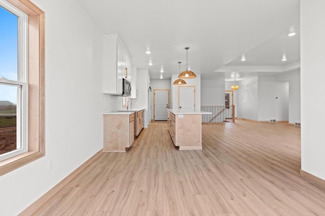 399 Battery Ave, De Pere, WI 54115 - kitchen with light wood finished floors, light countertops, white cabinetry, recessed lighting, and hanging light fixtures