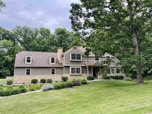 3590 Sabaka Trl, Verona, WI 53593 - view of front of home featuring stone siding, a front lawn, and a chimney