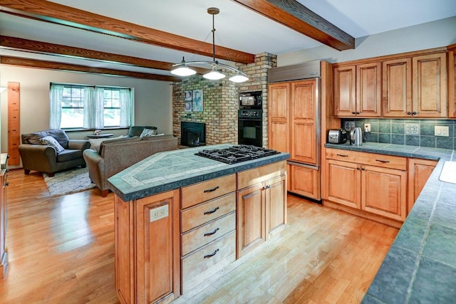 3590 Sabaka Trl, Verona, WI 53593 - kitchen with black appliances, light wood-type flooring, backsplash, decorative light fixtures, and a center island