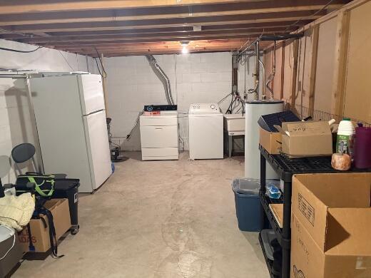 2408 Park Pl Unit D, Sheboygan, WI 53083 - unfinished below grade area with water heater, washer and clothes dryer, and freestanding refrigerator