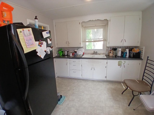 1415 S Kernan St, Appleton, WI 54915 - kitchen with freestanding refrigerator, dark countertops, backsplash, and white cabinetry