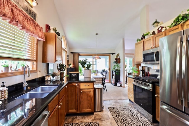 2360 Cobblestone Ln, Beloit, WI 53511 - kitchen with stainless steel appliances, dark stone countertops, pendant lighting, high vaulted ceiling, and a peninsula