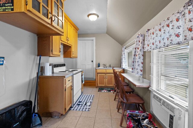 814 Quinney Ave, Kaukauna, WI 54130 - kitchen with electric range, light tile patterned flooring, glass insert cabinets, vaulted ceiling, and light countertops