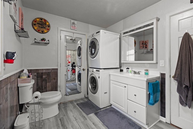814 Quinney Ave, Kaukauna, WI 54130 - bathroom with estacked washer and dryer, wood finished floors, vanity, and a wainscoted wall