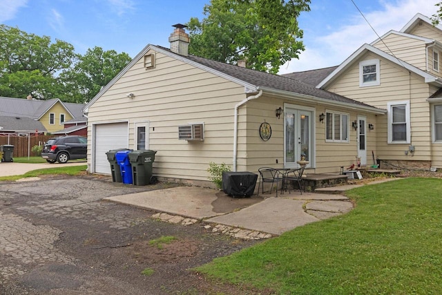 814 Quinney Ave, Kaukauna, WI 54130 - rear view of house with a chimney, a garage, french doors, a lawn, and driveway