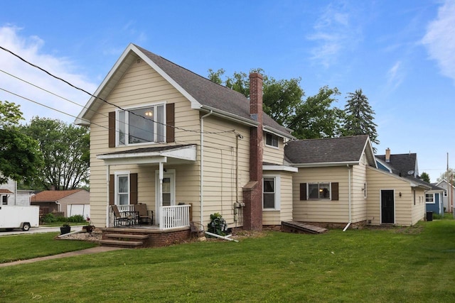 814 Quinney Ave, Kaukauna, WI 54130 - view of front facade featuring a chimney, a front yard, covered porch, and roof with shingles