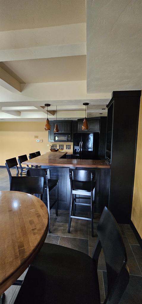 1400 Brooks Ln, Oshkosh, WI 54904 - kitchen with black appliances, decorative light fixtures, dark countertops, and dark cabinetry