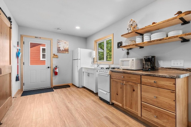 9347 Musky Bay Ln, Harshaw, WI 95429 - kitchen with white appliances, a barn door, light wood finished floors, dark countertops, and recessed lighting