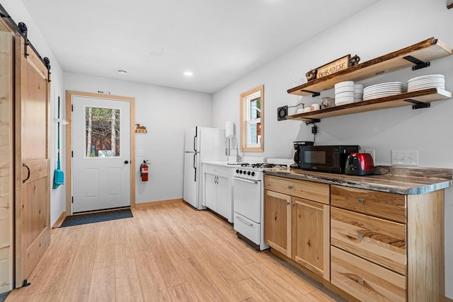 9347 Musky Bay Ln, Harshaw, WI 95429 - kitchen featuring white appliances, a barn door, light wood-style floors, open shelves, and dark countertops