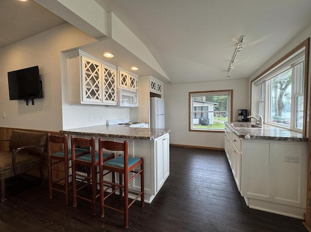 N2817 Rustic Dr, Clintonville, WI 54929 - kitchen featuring white appliances, white cabinets, a peninsula, light stone counters, and lofted ceiling