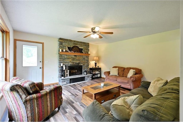 W5342 County Highway F, Trego, WI 54888 - living room featuring a ceiling fan, wood finished floors, and a stone fireplace
