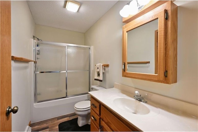 W5342 County Highway F, Trego, WI 54888 - full bath featuring wood finished floors, vanity, shower / bath combination with glass door, and a textured ceiling