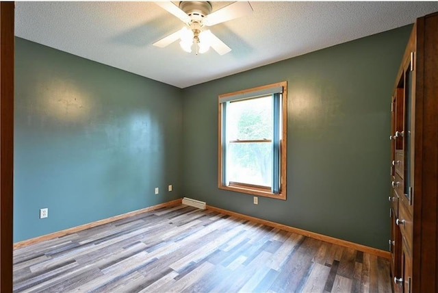 W5342 County Highway F, Trego, WI 54888 - unfurnished room featuring wood finished floors, ceiling fan, and a textured ceiling