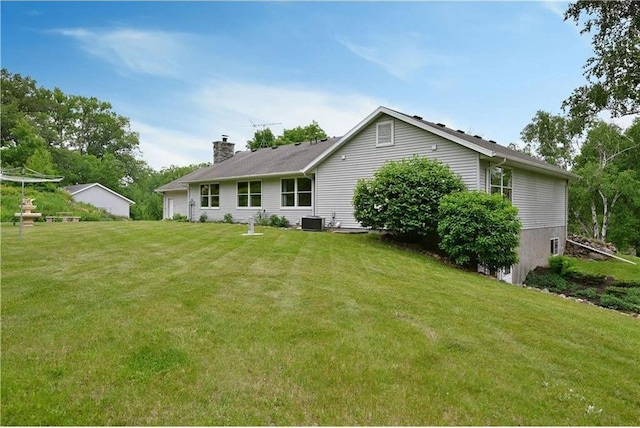 W5342 County Highway F, Trego, WI 54888 - rear view of property with a chimney, a lawn, and a garage