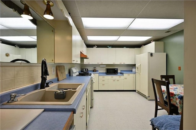 W5342 County Highway F, Trego, WI 54888 - kitchen with white appliances, a paneled ceiling, light floors, under cabinet range hood, and white cabinets