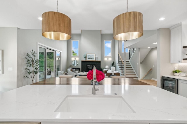 5928 Burning Prairie Dr, Waunakee, WI 53597 - kitchen featuring beverage cooler, open floor plan, healthy amount of natural light, hanging light fixtures, and recessed lighting