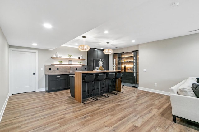 5928 Burning Prairie Dr, Waunakee, WI 53597 - indoor wet bar with recessed lighting, light wood finished floors, decorative backsplash, and pendant lighting