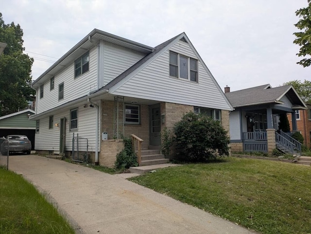 2759 N 57th St Unit 2761, Milwaukee, WI 53210 - view of front of home with a porch, a front yard, brick siding, and an outbuilding