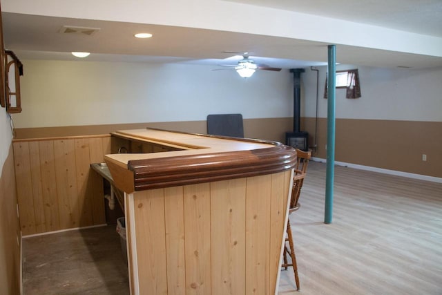 4303 E Milwaukee St Unit B, Janesville, WI 53546 - indoor dry bar with a wood stove, wood finished floors, recessed lighting, wood walls, and wainscoting
