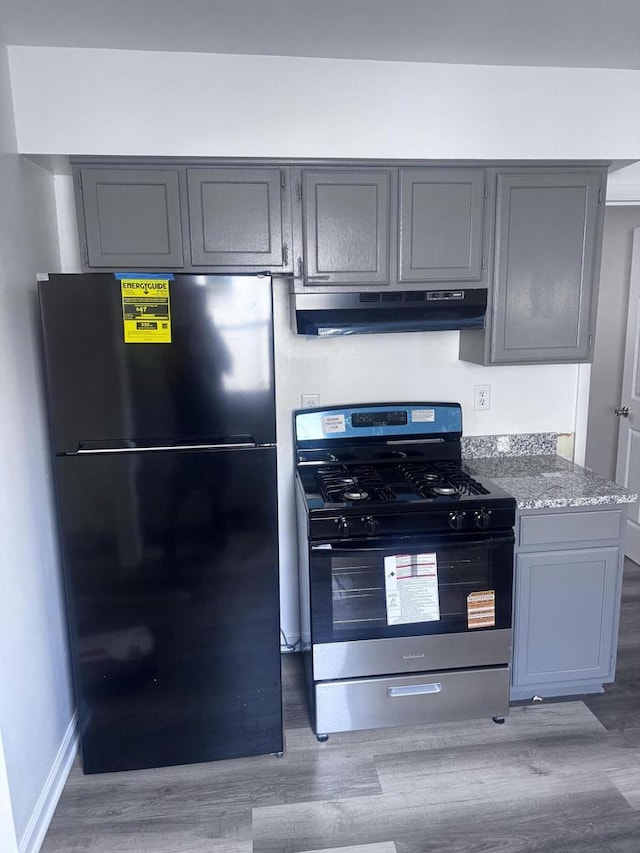 6337 13th Ave, Kenosha, WI 53143 - kitchen with freestanding refrigerator, gas range, under cabinet range hood, gray cabinets, and light wood-style floors