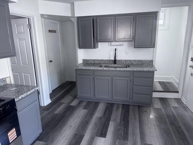 6337 13th Ave, Kenosha, WI 53143 - kitchen with dark wood finished floors, light stone counters, and gray cabinets