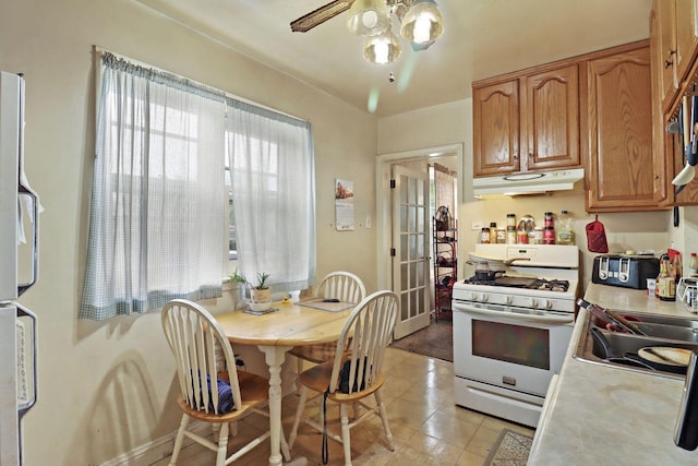 7732 15th Ave, Kenosha, WI 53143 - kitchen featuring white gas range, under cabinet range hood, light countertops, fridge, and a ceiling fan