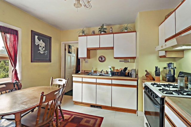 7732 15th Ave, Kenosha, WI 53143 - kitchen featuring range with gas stovetop, white cabinetry, light countertops, and under cabinet range hood