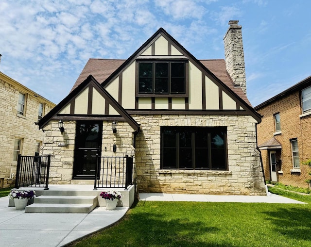 3441 N 55th St, Milwaukee, WI 53216 - rear view of house featuring stone siding, stucco siding, a lawn, a chimney, and roof with shingles