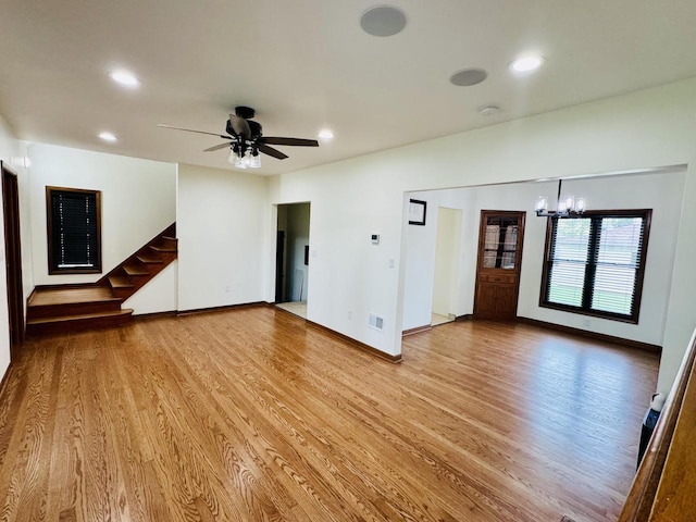3441 N 55th St, Milwaukee, WI 53216 - unfurnished living room with light wood finished floors, a chandelier, recessed lighting, a ceiling fan, and stairs