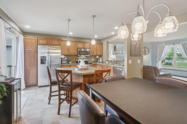 7042 Littlemore Dr, Madison, WI 53718 - kitchen with appliances with stainless steel finishes, light countertops, a center island, hanging light fixtures, and recessed lighting